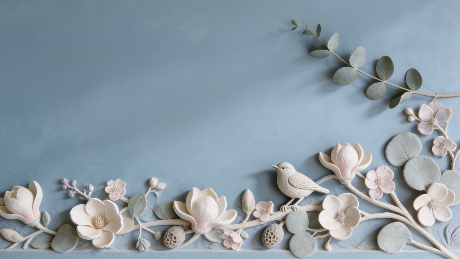 A hand-sculpted plaster relief of a songbird on a dusty-blue ground